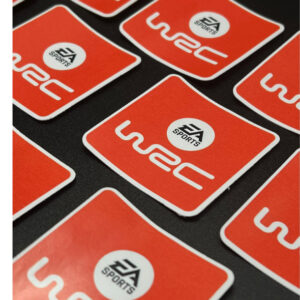 Square orange EA Sports WRC vinyl stickers displayed on a dark surface