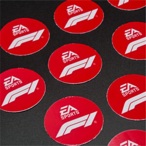 Round EA Sports F1 vinyl stickers displayed on a dark surface